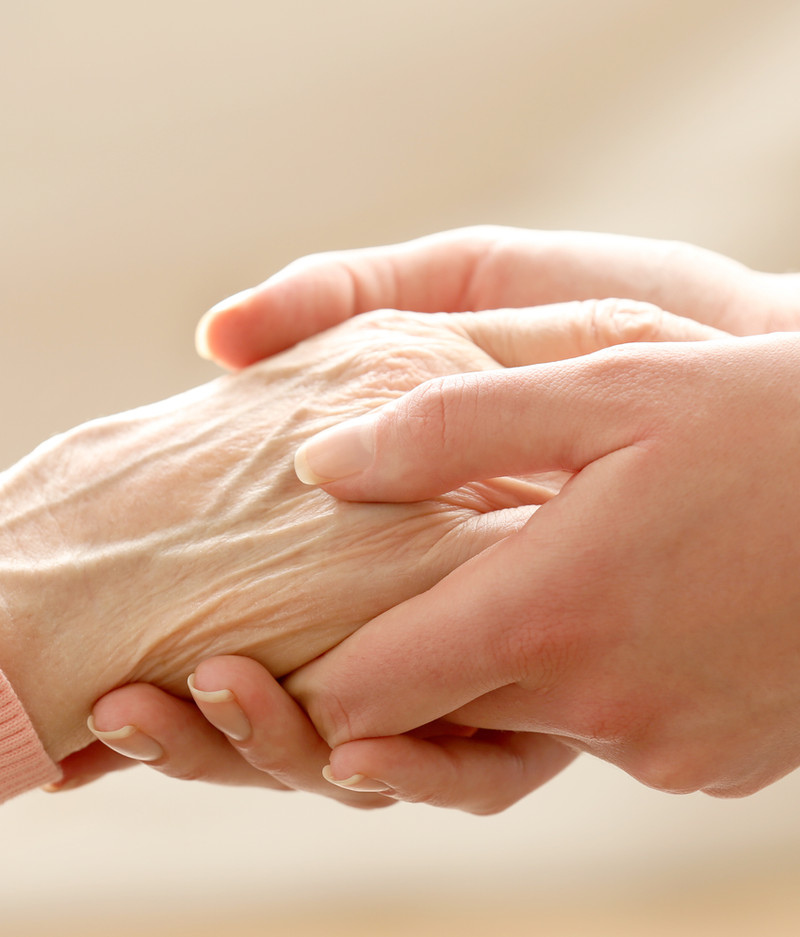 Caregiver holding a patient's hands
